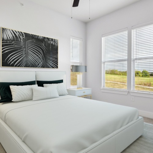 bedroom with lamps, white bed, modern wall art, windows