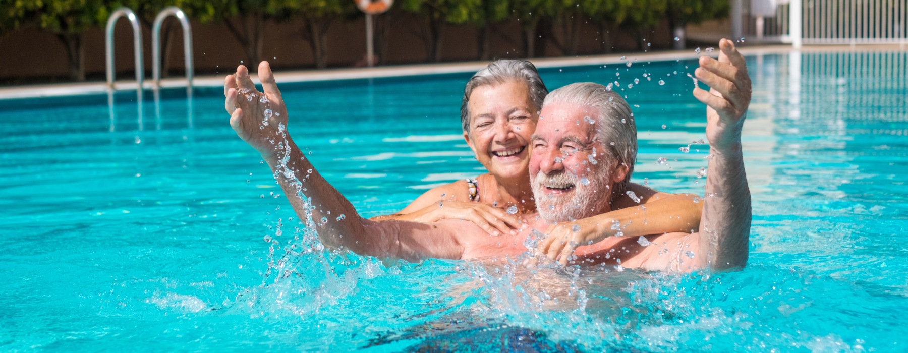 two people in a swimming pool laughing