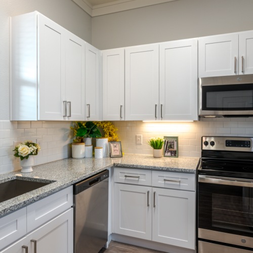 Model kitchen at Retreat at Krum senior living apartments in Krum, TX, featuring stainless steel appliances.
