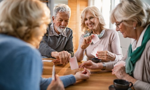 active senior adults playing cards and drinking coffee